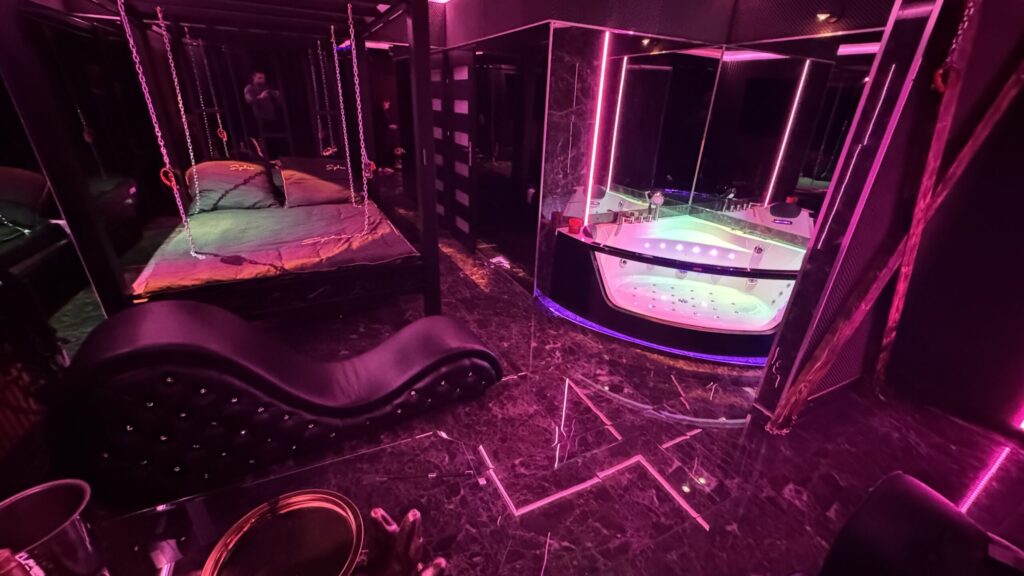 Nowoczesne wnętrze z łóżkiem, jacuzzi i różowym oświetleniem